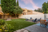 Backyard with artificial turf, patio, and firepit area
